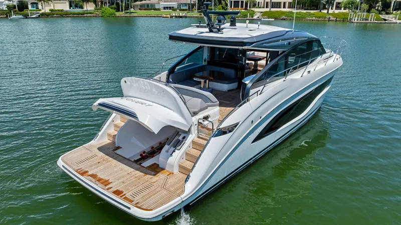 Slide: The Image of Sleek Cockpit Deck with Tender Garage The 2026 PRINCESS V55 showcases a stylish cockpit deck with a spacious tender garage, ideal for storing water toys or a small boat. The teak decking adds a touch of elegance, complemented by the modern lines and distinctive curves of the yacht's design. T - 6312373
