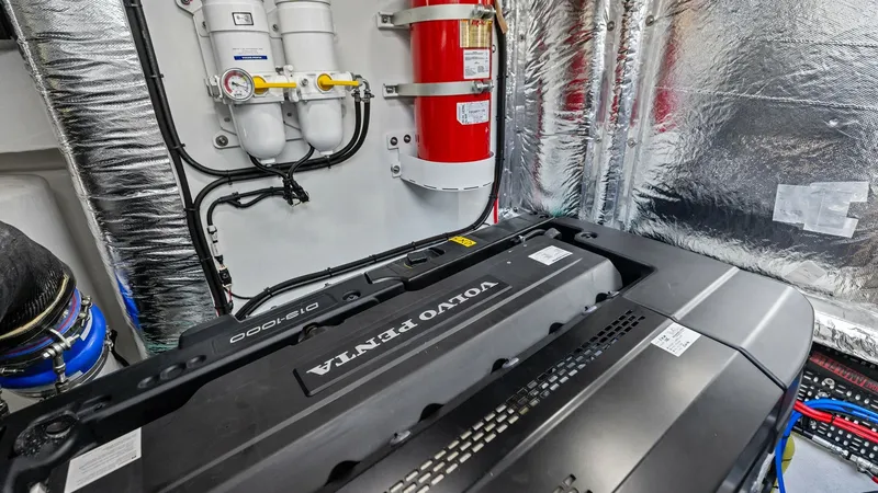 Slide: The Image of Engine Room with Volvo Penta Engine The engine room of the 2026 PRINCESS V55 features a powerful Volvo Penta engine, showcasing advanced engineering and reliability. The space is well-organized, with a neatly arranged filtration system and a prominent fire suppression system for safety. The - 6312375