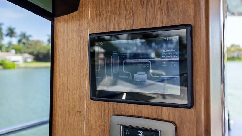 Slide: The Image of Spot Zero Advanced Water Filtration System Water Maker Combo Display Panel The 2026 PRINCESS V55 features a Spot Zero Water Maker Combo with a sleek, integrated control display panel set in rich wood cabinetry, offering seamless access to system monitoring. - 6312376