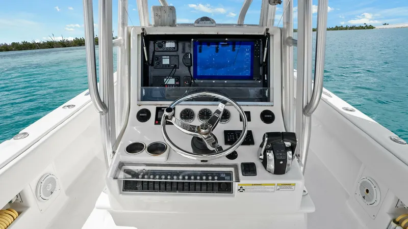 Slide: The Image of Helm Station with Electronics Display The helm station of the 2015 SeaVee 320Z features a modern electronics display and a well-organized control panel. The central steering wheel is flanked by easy-to-access switches and navigation controls, ensuring a seamless boating experience. With ample - 6312117