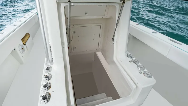 Slide: The Image of Cockpit Hatch with Step Access This image showcases the cockpit hatch of the 2015 SeaVee 320Z, providing access to the lower compartments. The hatch features secure handles and a robust locking mechanism, ensuring safety and stability at sea. Surrounding rod holders enhance the vessel' - 6312138