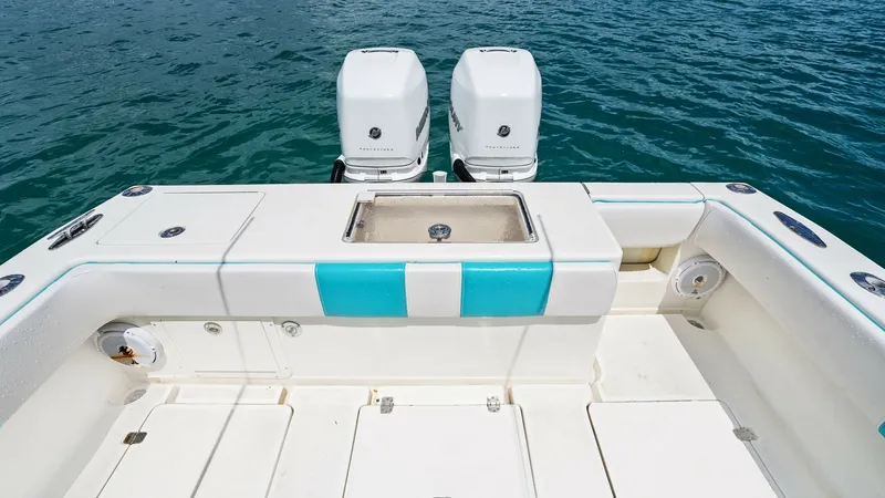 Slide: The Image of Aft Cockpit with Dual Engines This image showcases the aft cockpit of the 2015 SeaVee 320Z, featuring dual outboard engines for powerful performance. The spacious deck is designed for functionality, with a central live well and ample storage compartments. The clean, streamlined layout - 6312145