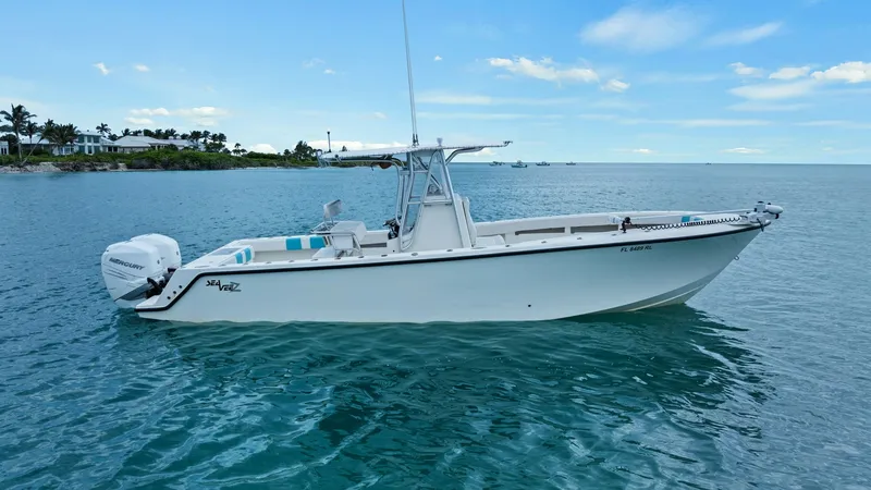 Slide: The Image of Side Profile of 2015 SeaVee 320Z This image showcases the sleek side profile of the 2015 SeaVee 320Z, featuring a robust center console design. The vessel's clean lines and spacious deck are complemented by twin outboard engines, offering both performance and efficiency. Ideal for fishin - 6312148
