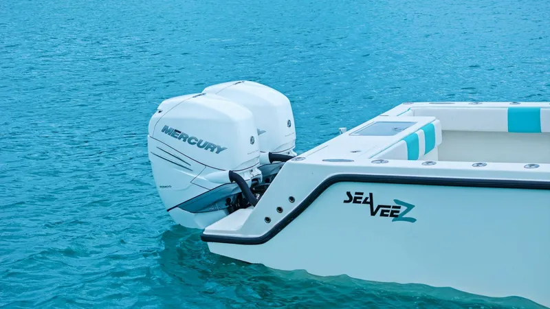 Slide: The Image of Aft View with Twin Mercury Engines This image showcases the aft section of the 2015 SeaVee 320Z, featuring powerful twin Mercury outboard engines. The sleek, modern design is complemented by a spacious deck area, perfect for fishing or leisure activities. The pristine white finish and turq - 6312150