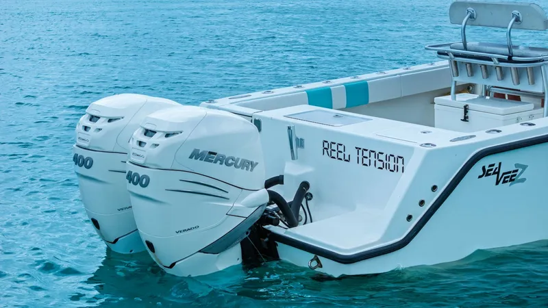 Slide: The Image of Aft Deck with Twin Engines This image showcases the powerful twin Mercury 400 engines on the 2015 SeaVee 320Z, named 'Reel Tension'. The sleek aft deck design is equipped with ample seating, providing both comfort and functionality for fishing or leisure activities. The clean lines - 6312151