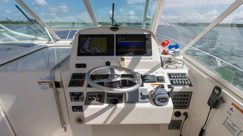 Slide: The Image of Helm Station with Electronics Display The helm station of the Wellcraft 360 Coastal offers a comprehensive navigation experience with dual electronic displays and a multifunction control panel. The ergonomic layout ensures ease of operation, complemented by a comfortable steering wheel and in - 6312510