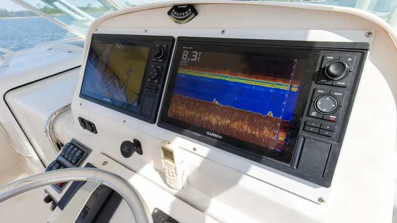 Slide: The Image of Helm Station with Dual Displays The helm of the 2006 Wellcraft 360 Coastal features dual Garmin displays, providing comprehensive navigation and fish-finding capabilities. The ergonomic design ensures easy access to controls and instruments, enhancing the captain's command experience. T - 6312511