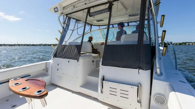 Slide: The Image of Spacious Aft Deck with Helm View The aft deck of the 2006 Wellcraft 360 Coastal offers ample space for activities, featuring a sleek fishing station with rod holders. The helm area is protected by a high-quality enclosure, providing excellent visibility and comfort for navigation. Ideal - 6312515