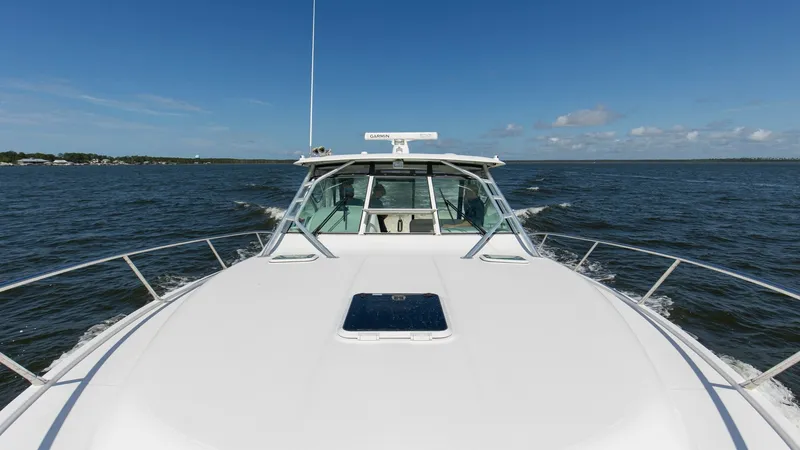 Slide: The Image of Bow View with Hardtop and Rails This image showcases the sleek bow of the 2006 Wellcraft 360 Coastal, featuring clean lines and a robust hardtop. The spacious foredeck is equipped with safety rails and a central hatch, providing functionality and style. The clear skies and open water em - 6312524