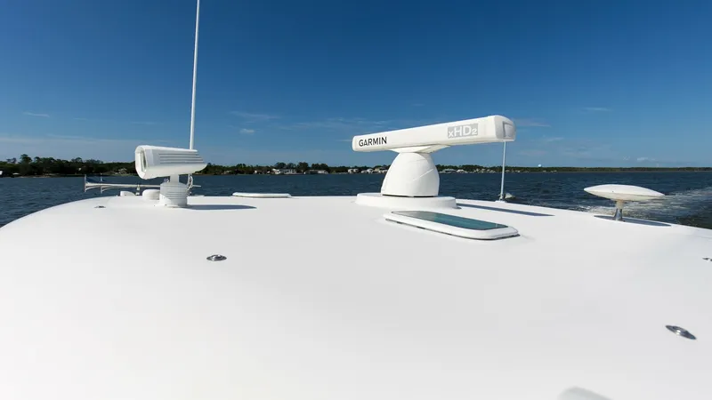 Slide: The Image of Bow with Radar and Antennas The bow of the 2006 Wellcraft 360 Coastal 'Unbridled' showcases a sleek, unobstructed deck equipped with advanced navigation technology. Prominently featured is a Garmin radar system, ensuring precise and reliable maritime navigation. The clean lines and - 6312525