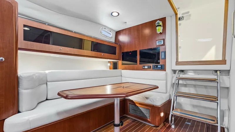Slide: The Image of Spacious Interior Dinette Area The interior of the 2006 Wellcraft 360 Coastal features a welcoming dinette with plush seating and a beautifully crafted wooden table, perfect for dining or socializing. The rich wood finishes complement the modern lighting, creating a warm and inviting a - 6312502