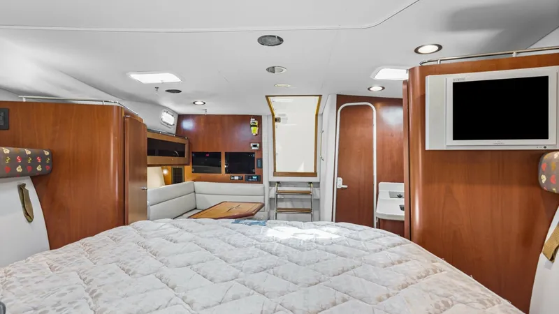 Slide: The Image of Spacious Interior Cabin View This inviting cabin on the 2006 Wellcraft 360 Coastal features a cozy sleeping area with a plush quilt, offering comfort and relaxation. The warm wood finishes create a welcoming atmosphere, complemented by ample natural light from overhead fixtures. A bu - 6312505