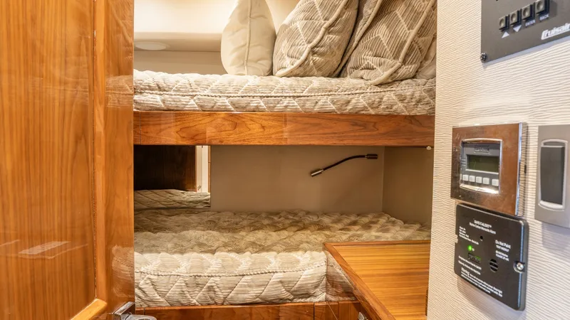 Slide: The Image of Guest Cabin with Bunk Beds This cozy guest cabin features well-appointed bunk beds, offering comfort and space efficiency on the Viking 92 Skybridge. The warm wood finishes and plush bedding create a welcoming atmosphere. Integrated lighting and modern control panels add to the cab - 6612516