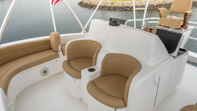 Slide: The Image of Skybridge Seating and Helm Station The Viking 92 Skybridge offers a luxurious seating area with plush, tan cushions, providing both comfort and style. The elevated helm station features advanced navigation equipment, ensuring seamless control and visibility. This spacious skybridge offers - 6612573