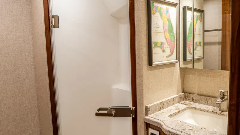 Slide: The Image of Elegant Ensuite Bathroom This luxurious ensuite bathroom on the Viking 92 Skybridge features a sleek glass shower door and refined marble countertop. The warm wood cabinetry and elegant wall art add a touch of sophistication, while the well-placed lighting enhances the inviting a - 6612533