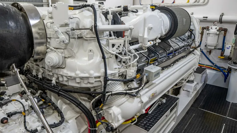 Slide: The Image of Engine Room with Power Unit This image showcases the pristine engine room of the Viking 92 Skybridge. The powerful engine is a focal point, surrounded by meticulously organized wiring and components, reflecting high engineering standards. The clean layout and modern equipment highli - 6612559