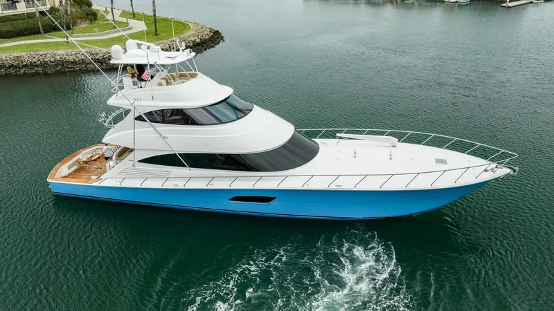 The Image of Side Profile of 92 Skybridge Exterior This image showcases the sleek side profile of the 2020 Viking 92 Skybridge, 'AFTER MIDNIGHT'. The vessel's aerodynamic design is accentuated by its striking blue hull and expansive windows, providing both style and panoramic views. The upper deck feature - 6612503