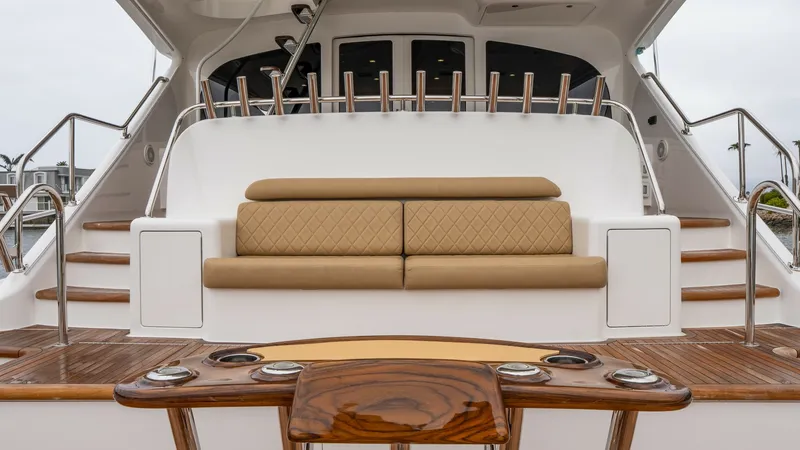 Slide: The Image of Aft Deck Seating Area The aft deck of the Viking 92 Skybridge features a luxurious seating area with plush, tan cushions and elegant stitching. The high-gloss teak table and trim add a touch of sophistication, complemented by stainless steel accents. This inviting space is per - 6612566