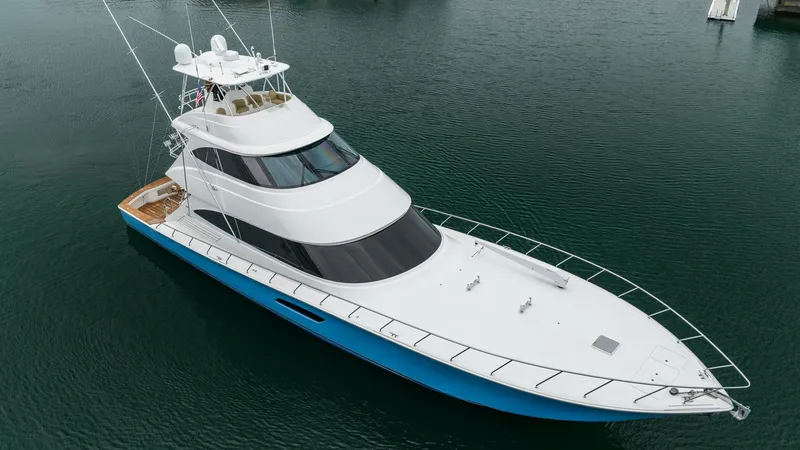 Slide: The Image of Aerial View of Skybridge and Bow This striking aerial shot showcases the sleek design of the Viking 92 Skybridge, highlighting its expansive bow and elegant skybridge. The vessel's smooth lines and sophisticated white and blue exterior make it stand out on the water. The skybridge offers - 6612577