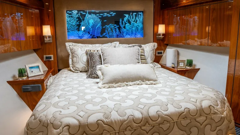 Slide: The Image of Luxurious Master Stateroom The master stateroom aboard the Viking 92 Skybridge exudes elegance with its plush bedding and sophisticated décor. Warm wood finishes and ambient lighting create a cozy and inviting atmosphere, complemented by a stunning illuminated marine art piece abo - 6612506