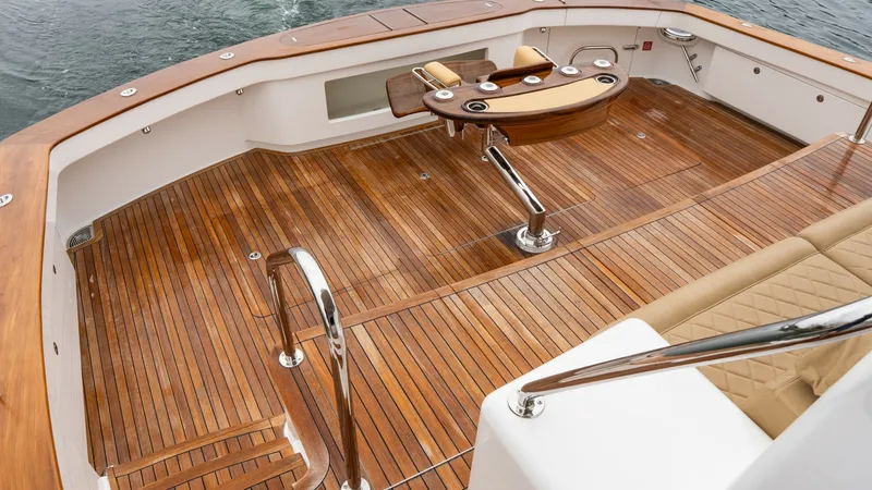 Slide: The Image of Teak Cockpit with Fishing Station This expansive teak cockpit on the Viking 92 Skybridge features a beautifully crafted fishing station, perfect for avid anglers. The polished wood finish enhances the elegance of the space, while stainless steel accents add a modern touch. With ample room - 6612564