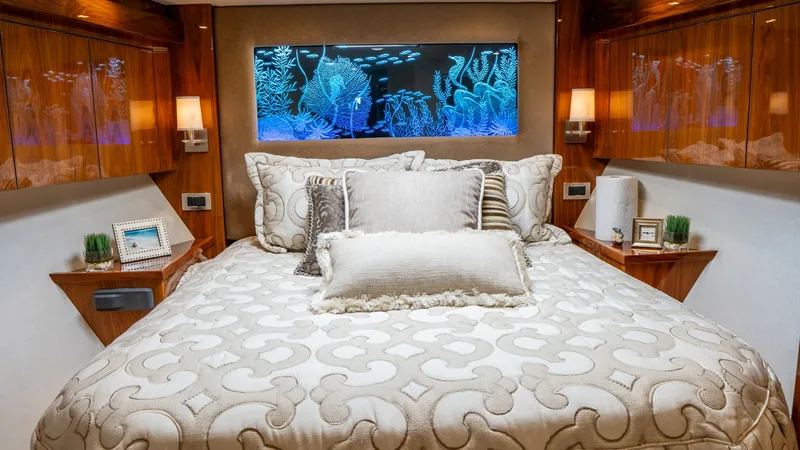 Slide: The Image of Luxurious Master Stateroom Interior The master stateroom of the 2020 Viking 92 Skybridge exudes elegance with its plush bedding and opulent decor. Rich wood finishes and ambient lighting create a warm, inviting atmosphere. A striking feature is the vibrant aquarium-style wall art, adding a - 6612517
