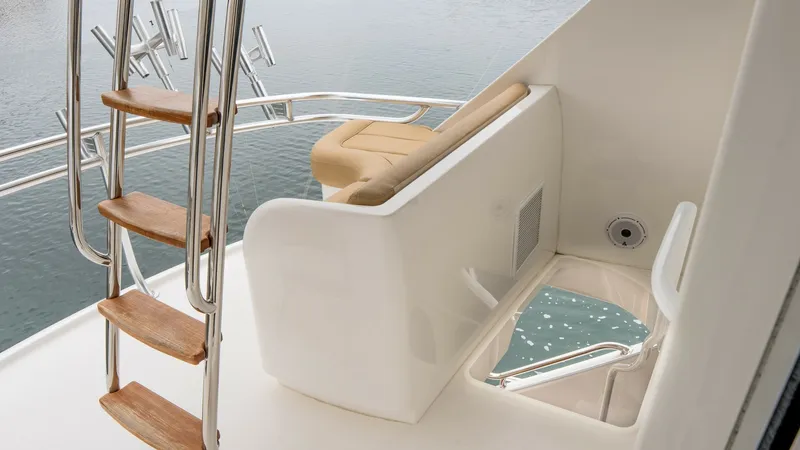 Slide: The Image of Flybridge Access and Seating Area This image showcases the stylish flybridge access with a sleek wooden ladder leading to an elevated seating area. The space features a comfortable bench with plush upholstery, ideal for enjoying panoramic views. Stainless steel railings and thoughtful des - 6612571