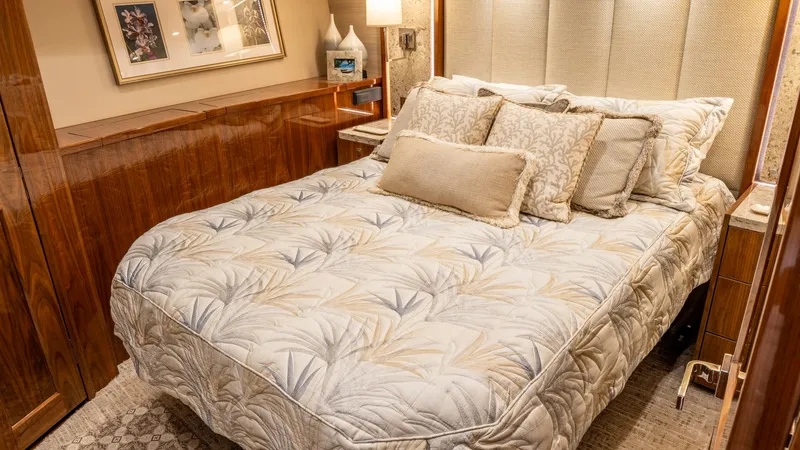 Slide: The Image of Luxurious Guest Stateroom Interior This elegant guest stateroom features a plush double bed adorned with luxurious bedding and an array of soft pillows. The warm wood finishes and soft ambient lighting create a cozy, inviting atmosphere. Thoughtful details, such as the decorative artwork a - 6612527