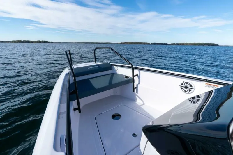 Slide: The Image of Axopar 22 T-Top Bow Seating Forward view of the Axopar 22 T-Top’s bow bench seat with clean white upholstery and stainless grab rails, showcasing the open, social layout. Photographed by East Coast Yacht Sales in Casco Bay, Maine. - 7383419