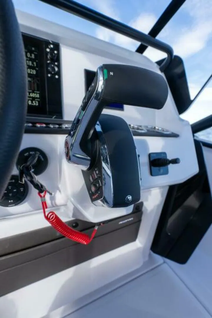 Slide: The Image of Axopar 22 T-Top Throttle and Engine Controls Detailed view of the Axopar 22 T-Top’s throttle and engine controls, showcasing precise handling and ergonomic design for confident performance on the water. Photo by East Coast Yacht Sales in Casco Bay, Maine. - 7383409