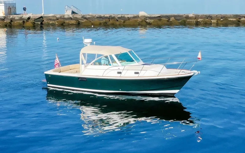 Slide: The Image of Hunt Surfhunter 29 - Judith Ann 2005 Hunt Yachts Surfhunter 29 boat on calm water near rocky shore. - 6302467