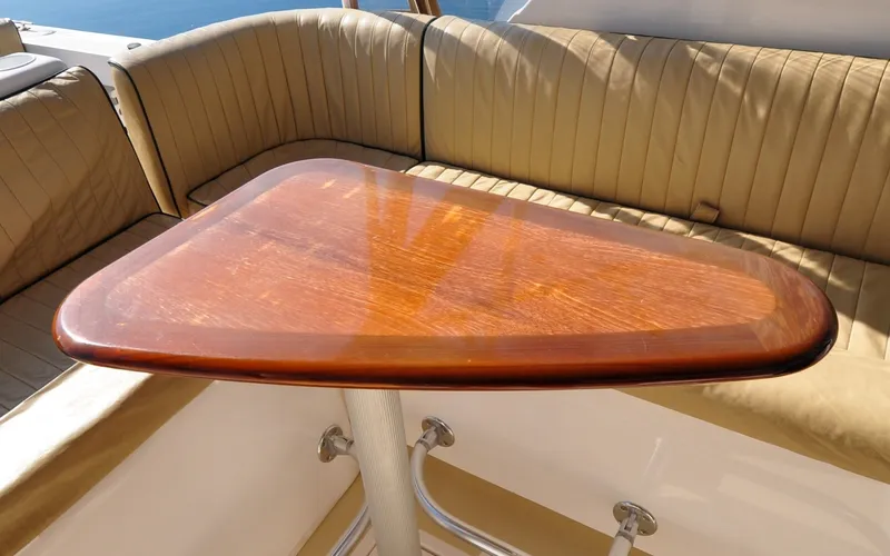 Slide: The Image of Hunt Surfhunter 29 - Judith Ann Luxurious wooden table on 2005 Hunt Yachts Surfhunter 29, surrounded by cushioned seating. - 6302513