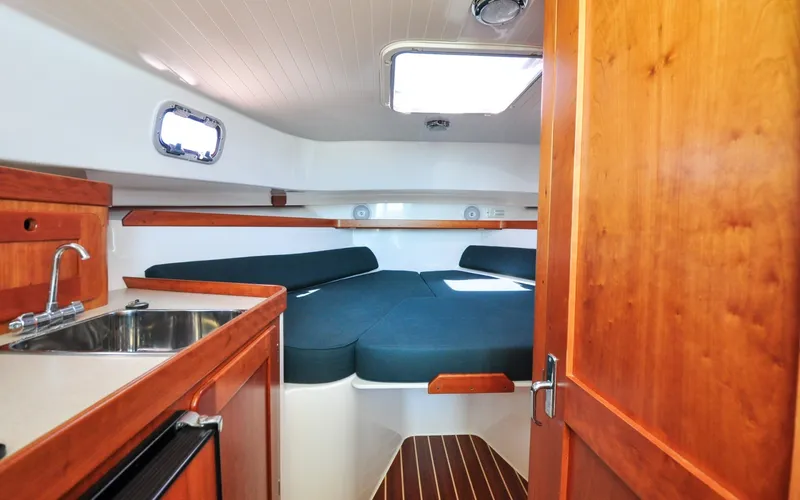 Slide: The Image of Hunt Surfhunter 29 - Judith Ann 2005 Hunt Yachts Surfhunter 29 cabin interior with wood finish and compact kitchenette. - 6302486