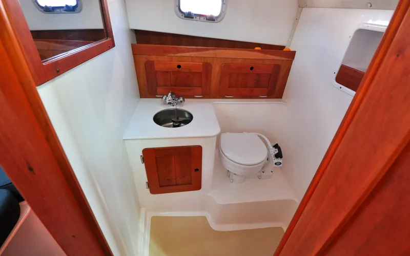 Slide: The Image of Hunt Surfhunter 29 - Judith Ann 2005 Hunt Yachts Surfhunter 29 bathroom with sink, toilet, and wooden cabinetry. - 6302484