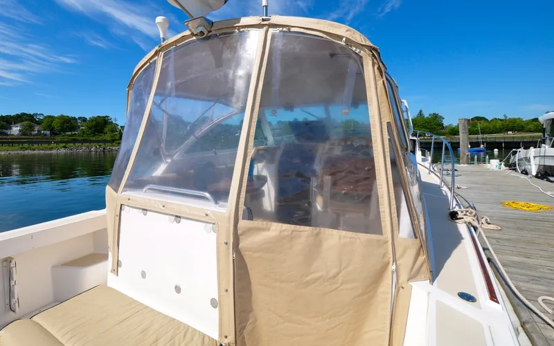 Slide: The Image of Hunt Surfhunter 29 - Judith Ann 2005 Hunt Yachts Surfhunter 29 with tan canopy docked by calm waters. - 6302534