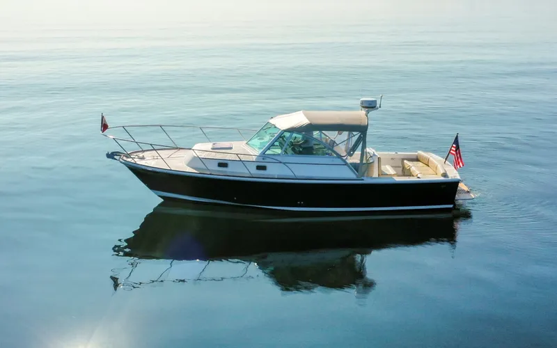 Slide: The Image of Hunt Surfhunter 29 - Judith Ann 2005 Hunt Yachts Surfhunter 29 cruising on calm waters, featuring sleek design and American flag. - 6302471