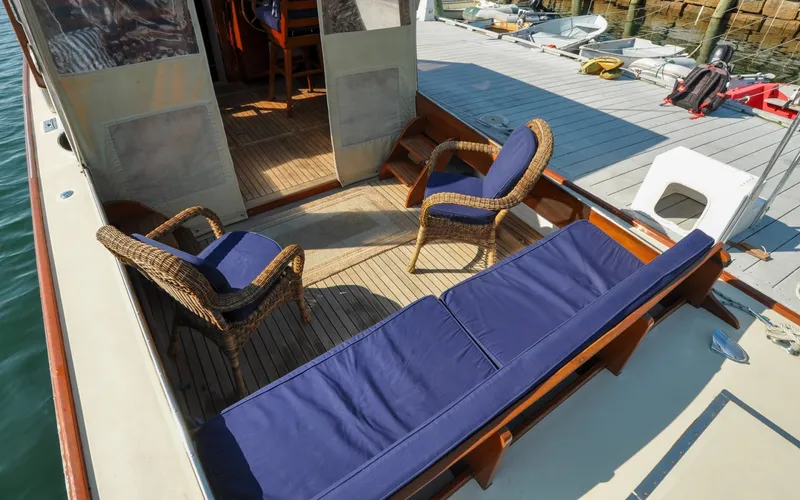 Slide: The Image of 1958 Bunker and Ellis 42 | Aleria 1958 Bunker and Ellis 42 boat deck with wicker chairs and blue cushions. - 6307464
