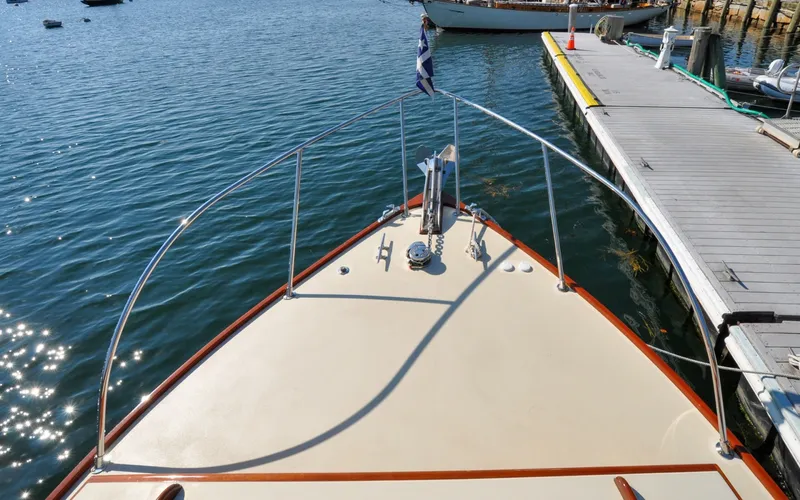 Slide: The Image of 1958 Bunker and Ellis 42 | Aleria Bow view of a 1958 Bunker and Ellis 42 boat docked on calm water. - 6307432