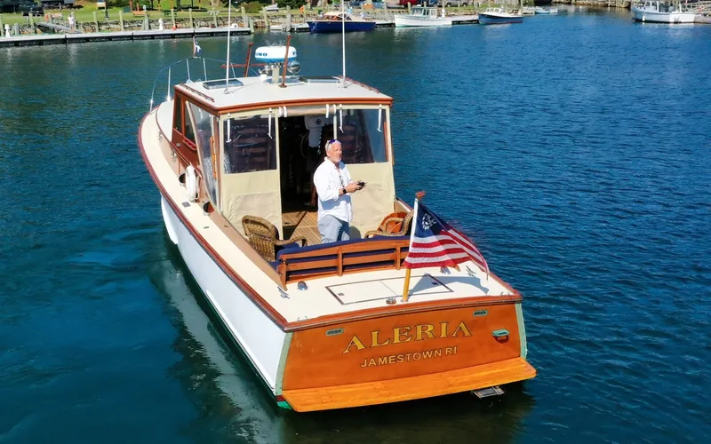 Slide: The Image of 1958 Bunker and Ellis 42 | Aleria 1958 Bunker and Ellis 42 boat named "Aleria" on water, featuring American flag. - 6307424