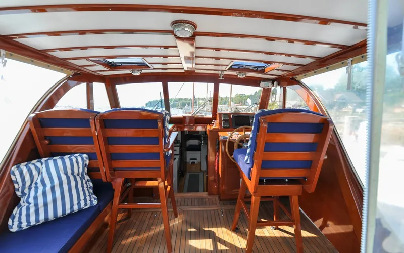 Slide: The Image of 1958 Bunker and Ellis 42 | Aleria Interior of a 1958 Bunker and Ellis 42 boat with wooden seating and blue cushions. - 6307434
