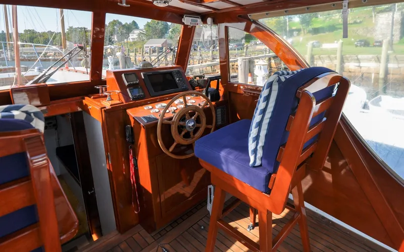 Slide: The Image of 1958 Bunker and Ellis 42 | Aleria Vintage 1958 Bunker and Ellis 42 boat interior with wooden helm and blue cushioned seat. - 6307481