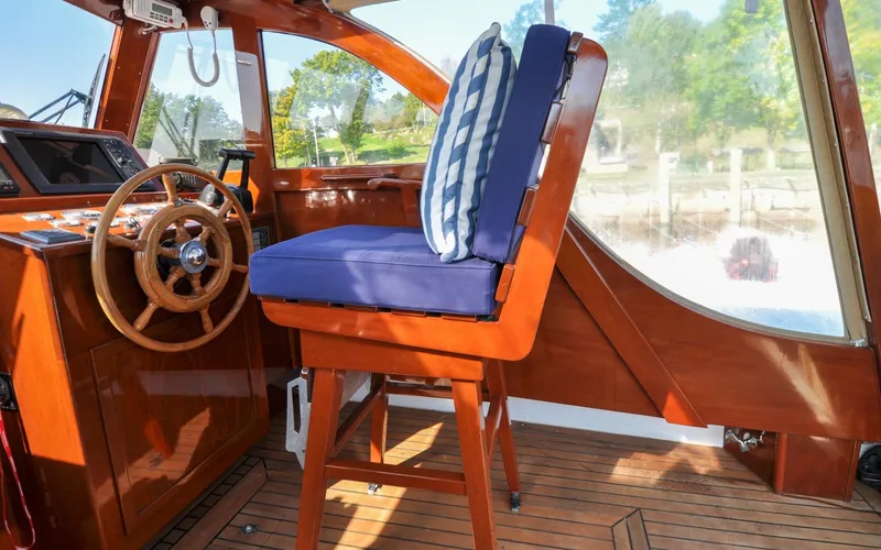 Slide: The Image of 1958 Bunker and Ellis 42 | Aleria Vintage 1958 Bunker and Ellis 42 boat interior with wooden helm and cushioned seat. - 6307435