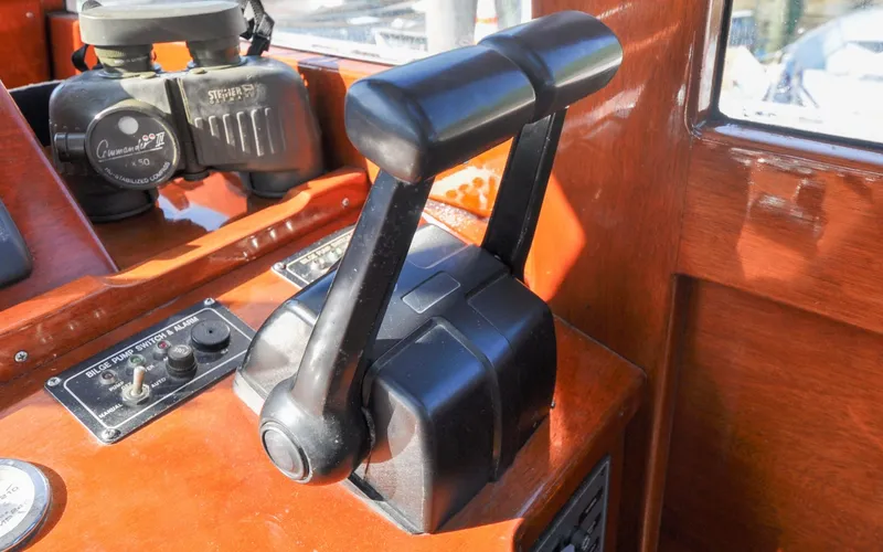 Slide: The Image of 1958 Bunker and Ellis 42 | Aleria Throttle controls and binoculars on a 1958 Bunker and Ellis 42 boat dashboard. - 6307487