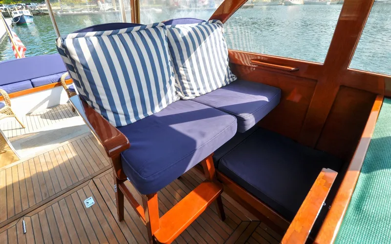 Slide: The Image of 1958 Bunker and Ellis 42 | Aleria Vintage 1958 Bunker and Ellis 42 boat interior with striped cushions and wooden seating. - 6307439