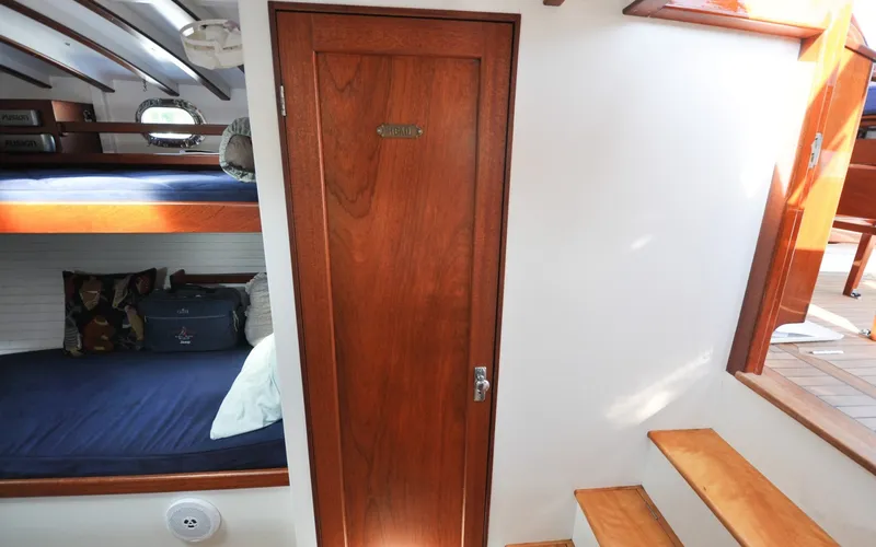 Slide: The Image of 1958 Bunker and Ellis 42 | Aleria Interior of 1958 Bunker and Ellis 42 boat with wooden door and bunk beds. - 6307548