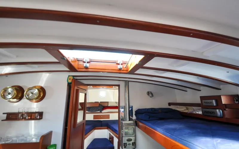 Slide: The Image of 1958 Bunker and Ellis 42 | Aleria Interior of a 1958 Bunker and Ellis 42 boat with wooden accents and cozy sleeping area. - 6307550