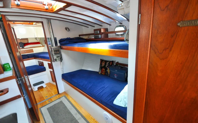 Slide: The Image of 1958 Bunker and Ellis 42 | Aleria Interior of a 1958 Bunker and Ellis 42 boat with wooden bunks and blue bedding. - 6307445