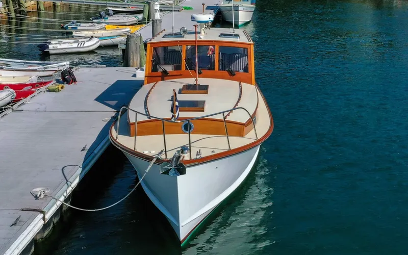 Slide: The Image of 1958 Bunker and Ellis 42 | Aleria Classic 1958 Bunker and Ellis 42 boat docked at a marina, showcasing elegant wooden design. - 6307409