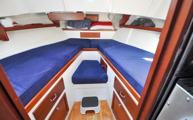 Slide: The Image of 1958 Bunker and Ellis 42 | Aleria 1958 Bunker and Ellis 42 boat cabin with blue cushions and wooden storage. - 6307448