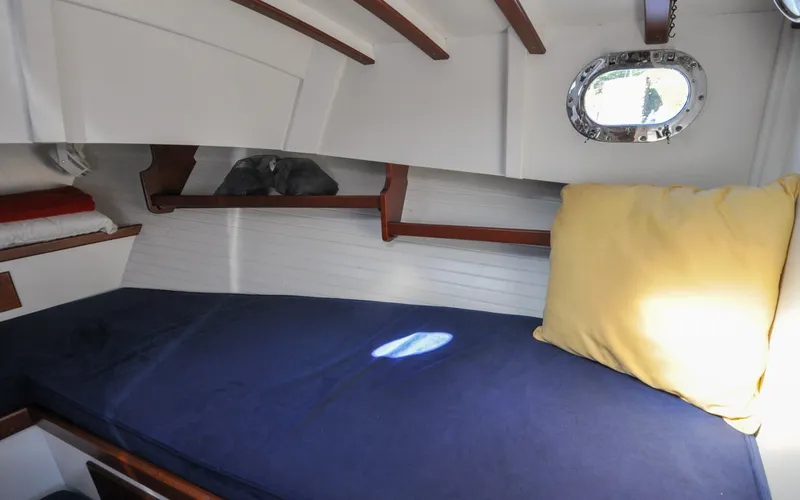 Slide: The Image of 1958 Bunker and Ellis 42 | Aleria Cozy cabin interior of 1958 Bunker and Ellis 42 boat with blue bedding and porthole. - 6307511